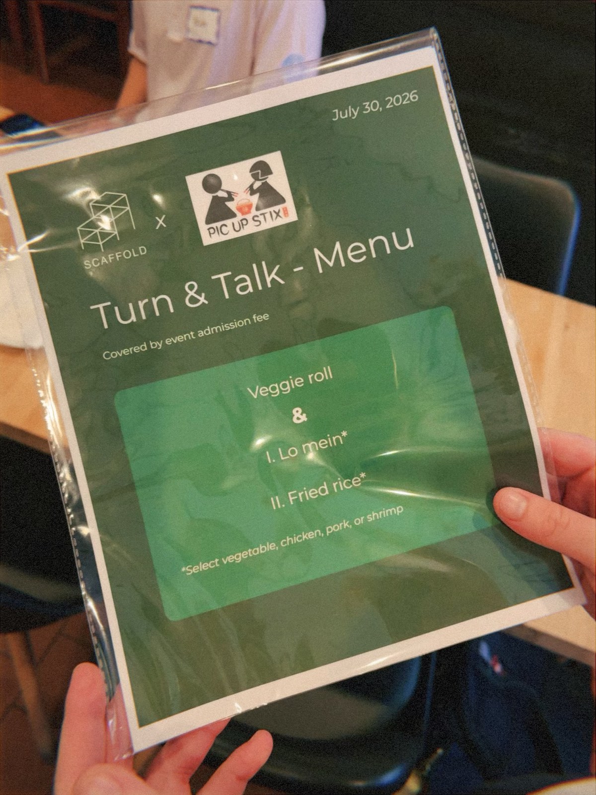A laminated menu for the event, headed Scaffold x Pic Up Stix, Turn & Talk — Menu, July 30, 2026, listing a veggie roll with lo mein or fried rice.